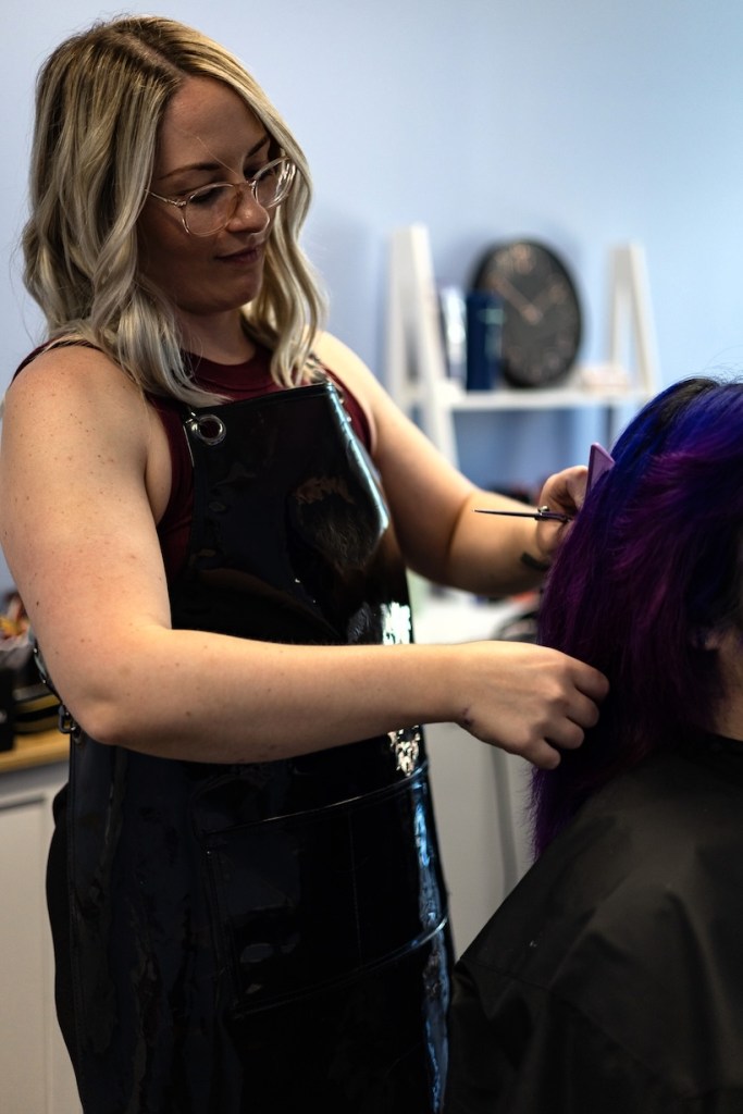 Jessie cutting a client's hair.
